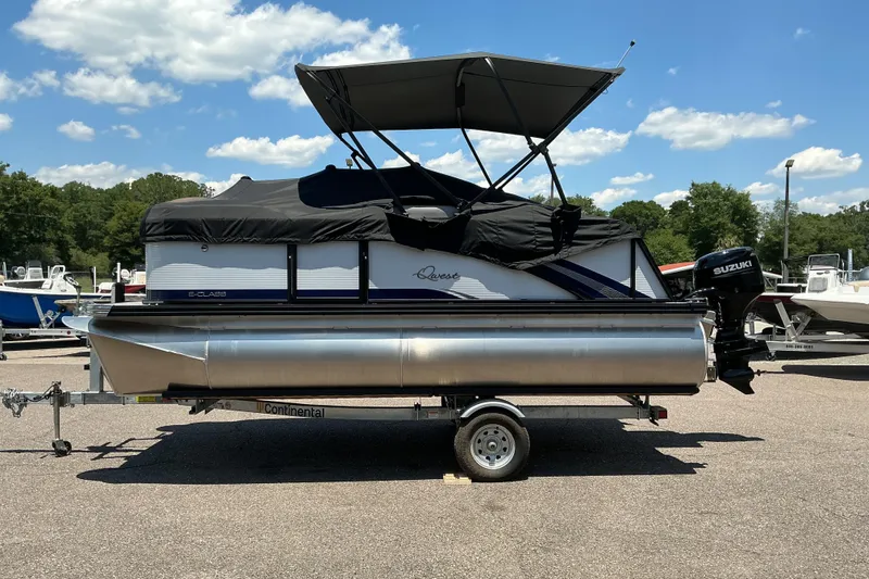Slide: The Image of 2026 Qwest Lanai 816 pontoon boat on trailer, featuring a Suzuki outboard motor. - 23
