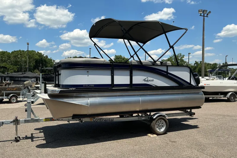 Slide: The Image of 2026 Qwest Lanai 816 pontoon boat on trailer under clear blue sky. - 5