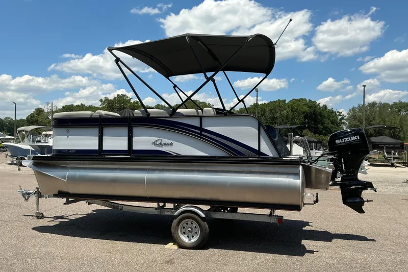 Slide: The Image of 2026 Qwest Lanai 816 pontoon boat with Suzuki motor on a trailer, under a sunny sky. - 6