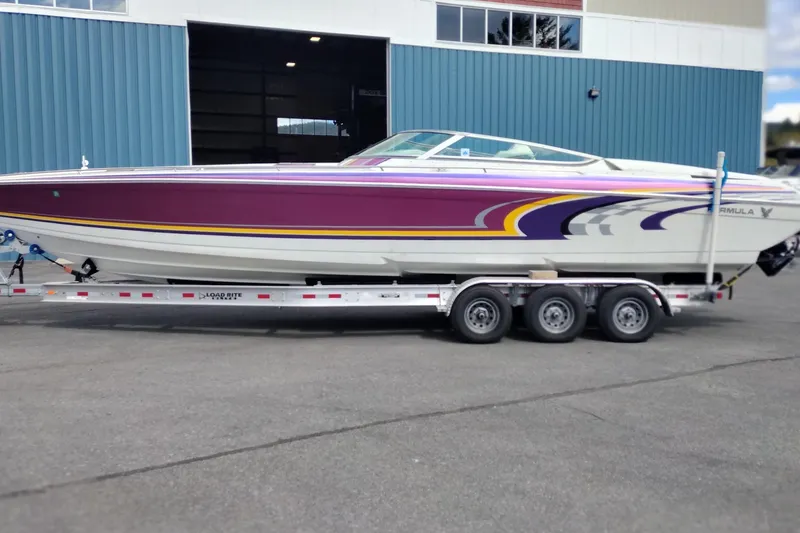 The Image of 2006 Formula 353 FASTech speedboat on trailer, featuring vibrant purple and yellow design. - 1