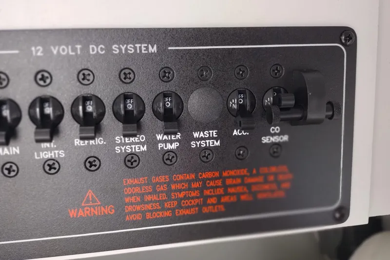 Slide: The Image of Control panel of a 2006 Formula 353 FASTech boat with various switches and warning label. - 24
