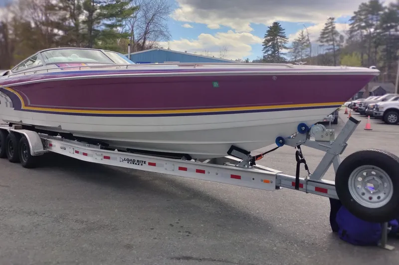 Slide: The Image of 2006 Formula 353 FASTech boat on trailer, vibrant purple and yellow design, parked outdoors. - 3