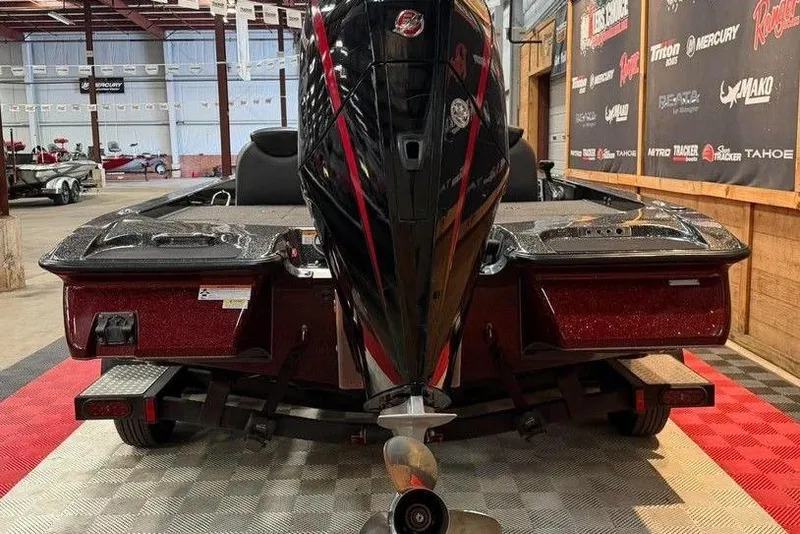 Slide: The Image of 2022 Caymas CX 19 boat with powerful outboard motor in showroom setting. - 2