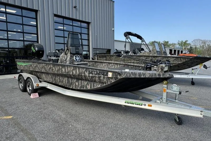 The Image of 2023 Havoc 1756 MRST boat on trailer, camo design, parked outside dealership. - 1