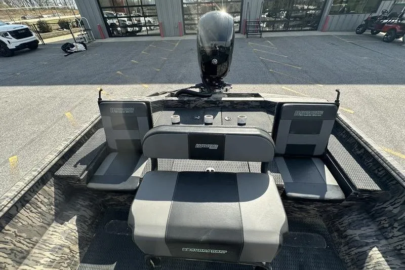 Slide: The Image of 2023 Havoc 1756 MRST boat interior with seating and motor, parked outdoors. - 10