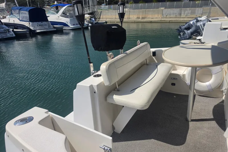 Slide: The Image of 2000 Bayliner 2855 Ciera boat interior with seating and table in marina setting. - 11