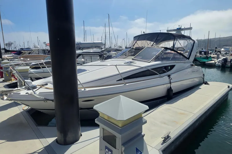 Slide: The Image of 2000 Bayliner 2855 Ciera docked at marina, surrounded by other boats under a clear sky. - 2