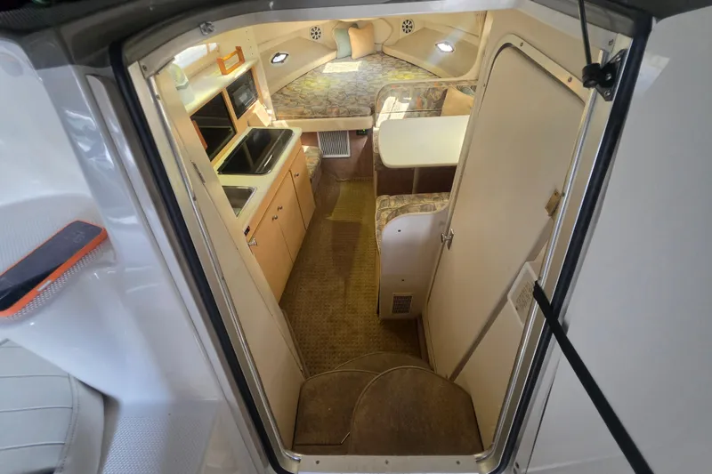 Slide: The Image of Interior view of a 2000 Bayliner 2855 Ciera boat, featuring a compact kitchen and seating area. - 20