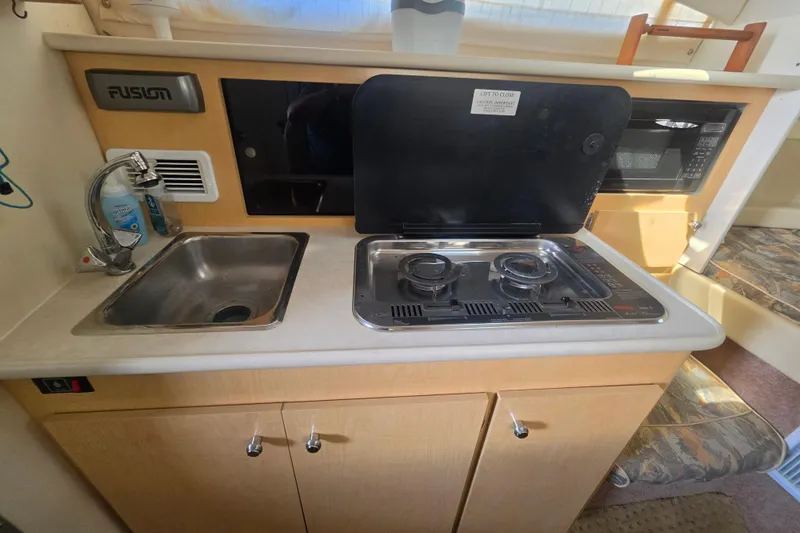 Slide: The Image of Compact kitchen area in a 2000 Bayliner 2855 Ciera boat with stove and sink. - 23