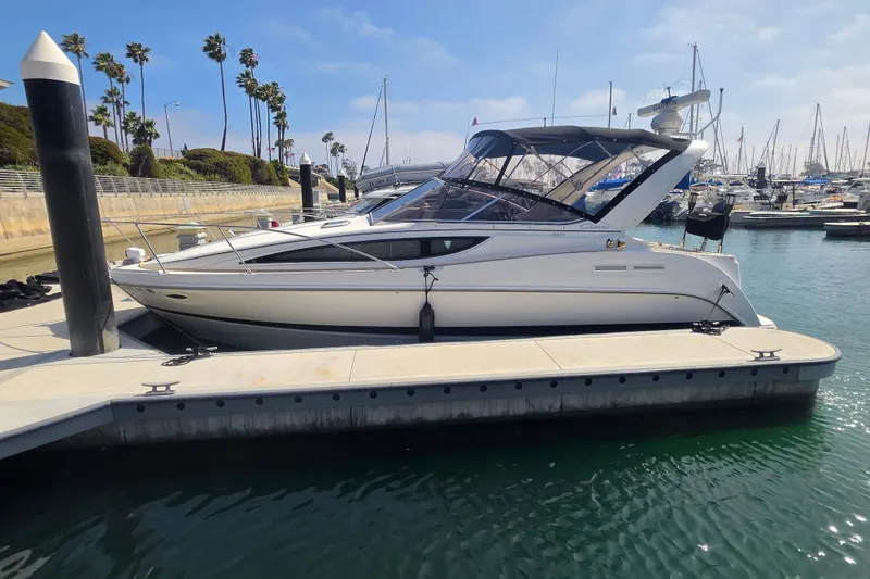 Slide: The Image of 2000 Bayliner 2855 Ciera docked at a marina with clear skies and palm trees. - 3