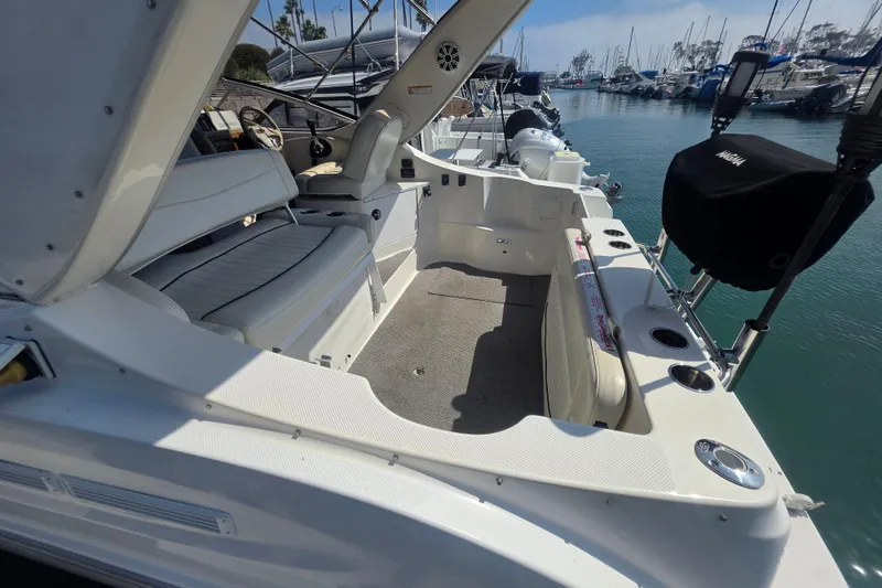 Slide: The Image of 2000 Bayliner 2855 Ciera boat interior, featuring seating and helm, docked in a marina. - 8