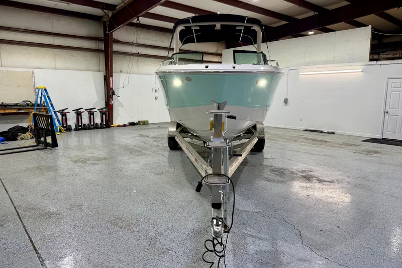 Slide: The Image of 2023 Chaparral 270 OSX boat on trailer in a spacious indoor garage. - 12