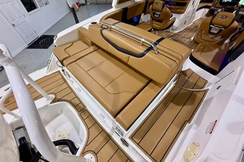 Slide: The Image of 2023 Chaparral 270 OSX boat interior with tan leather seating and wood-style flooring. - 17
