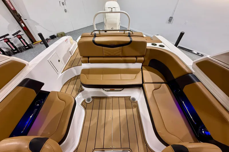Slide: The Image of 2023 Chaparral 270 OSX boat interior with tan leather seating and wood-style flooring. - 21