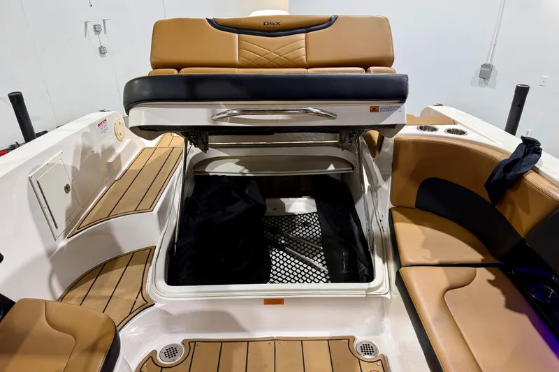 Slide: The Image of 2023 Chaparral 270 OSX boat interior with open storage compartment and tan seating. - 22