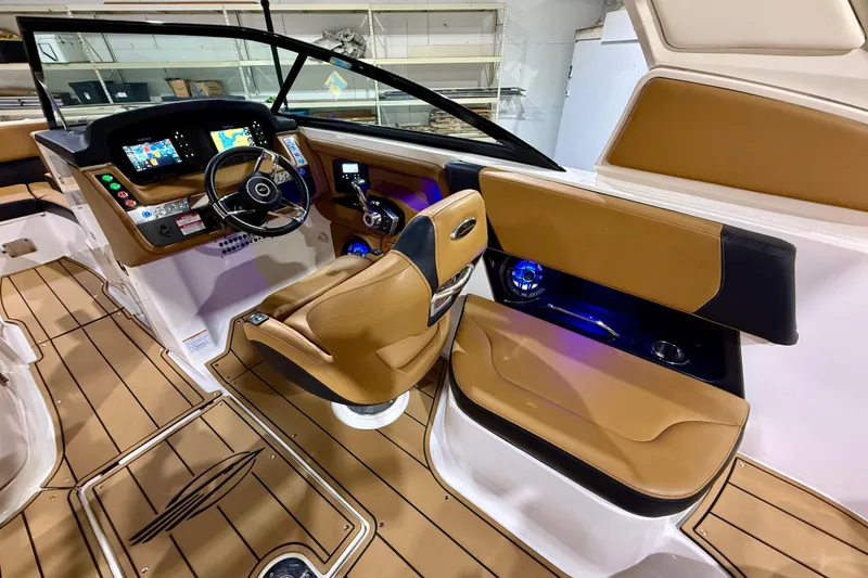 Slide: The Image of 2023 Chaparral 270 OSX boat interior with modern dashboard and tan seating. - 25