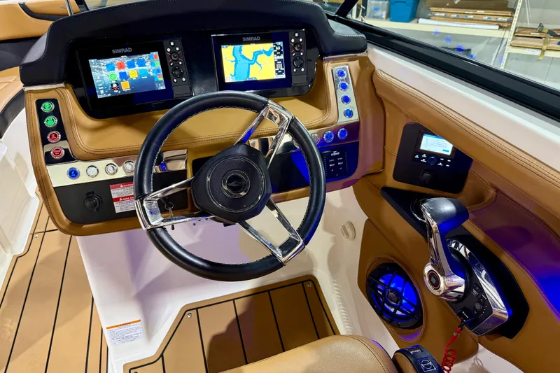 Slide: The Image of 2023 Chaparral 270 OSX boat dashboard with dual Simrad displays and modern controls. - 27