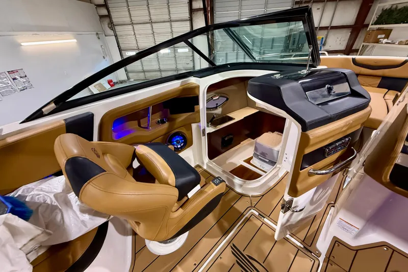 Slide: The Image of 2023 Chaparral 270 OSX boat interior with tan leather seating and modern dashboard. - 30
