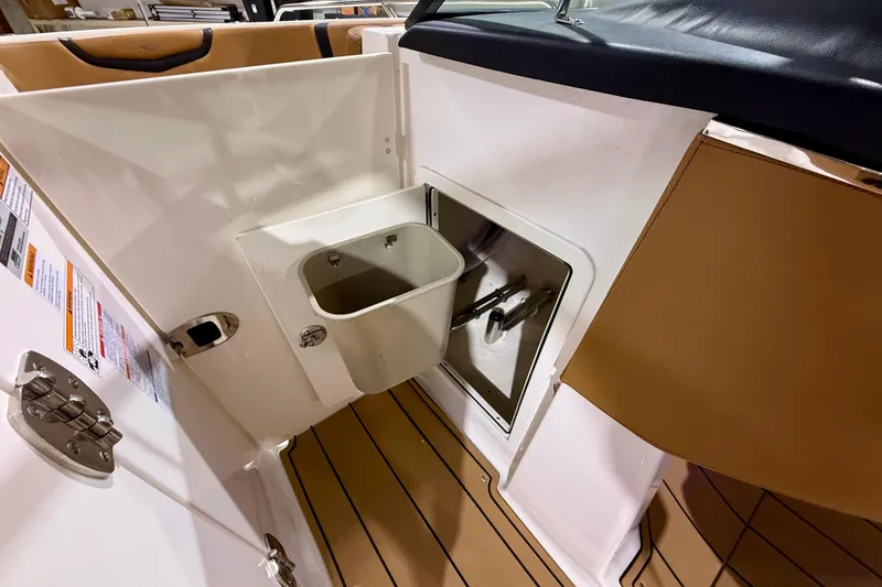 Slide: The Image of 2023 Chaparral 270 OSX boat interior with storage compartment and tan seating. - 35