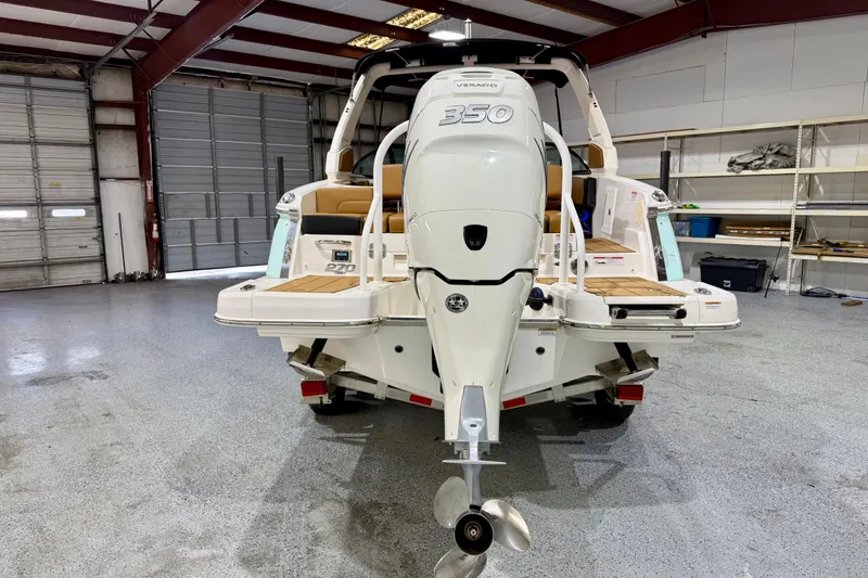 Slide: The Image of 2023 Chaparral 270 OSX boat with powerful outboard motor in a spacious garage. - 5