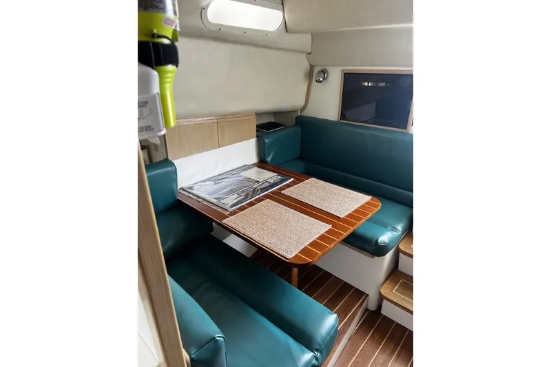 Slide: The Image of Interior of 1993 Blackfin 31 Combi boat with teal seating and wooden table. - 10