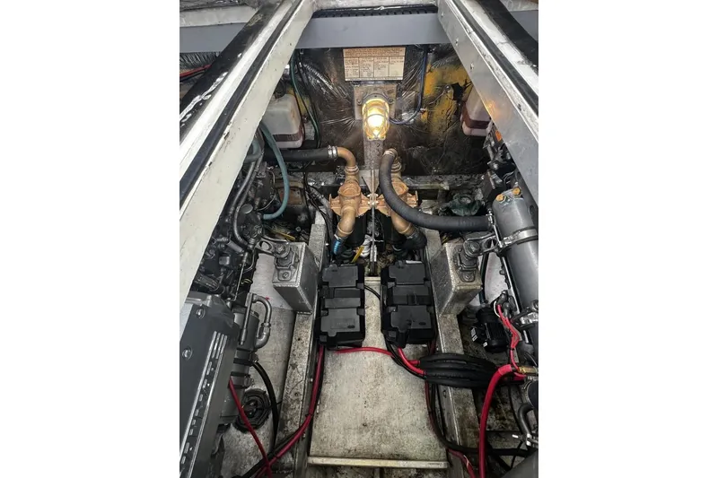 Slide: The Image of Engine compartment of a 1993 Blackfin 31 Combi boat, showcasing mechanical components and wiring. - 11