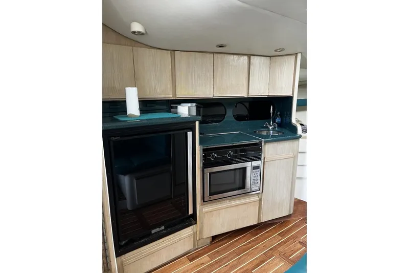 Slide: The Image of 1993 Blackfin 31 Combi yacht interior kitchen with wood cabinets, microwave, and sink. - 7