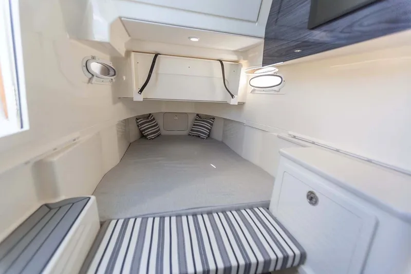 Slide: The Image of Manufacturer Provided Image: 2020 Cobia 350 Center Console cabin interior with striped cushions and portholes. - 19