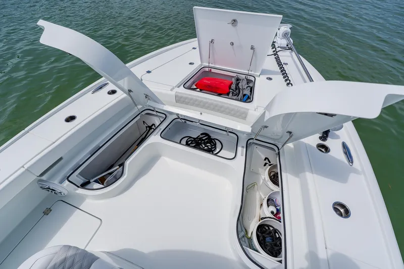 Slide: The Image of 2023 Freeman 28 boat deck with open storage compartments and gear. - 14