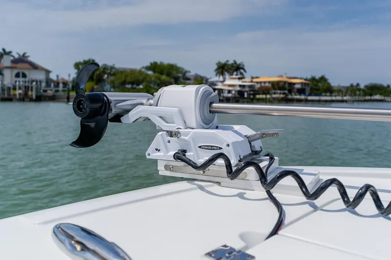 Slide: The Image of Trolling motor on a 2023 Freeman 28 boat, docked near waterfront homes. - 15