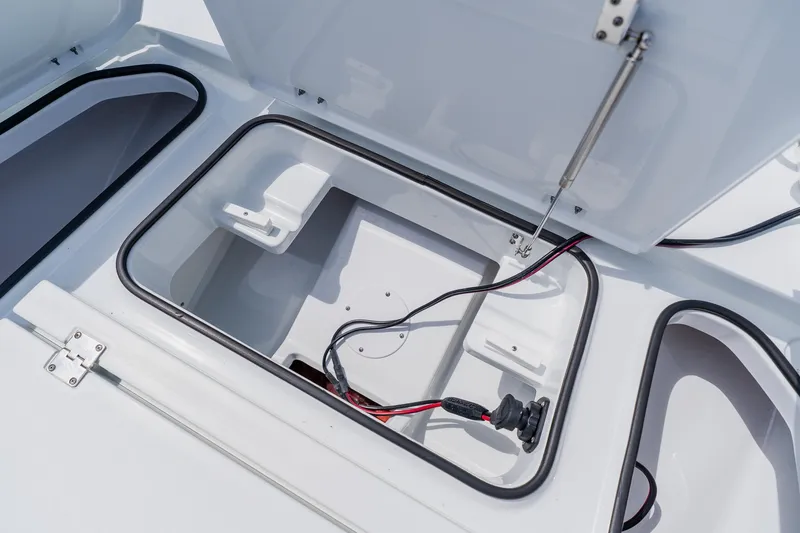 Slide: The Image of Open storage compartment on a 2023 Freeman 28 boat, featuring wiring and hydraulic support. - 17
