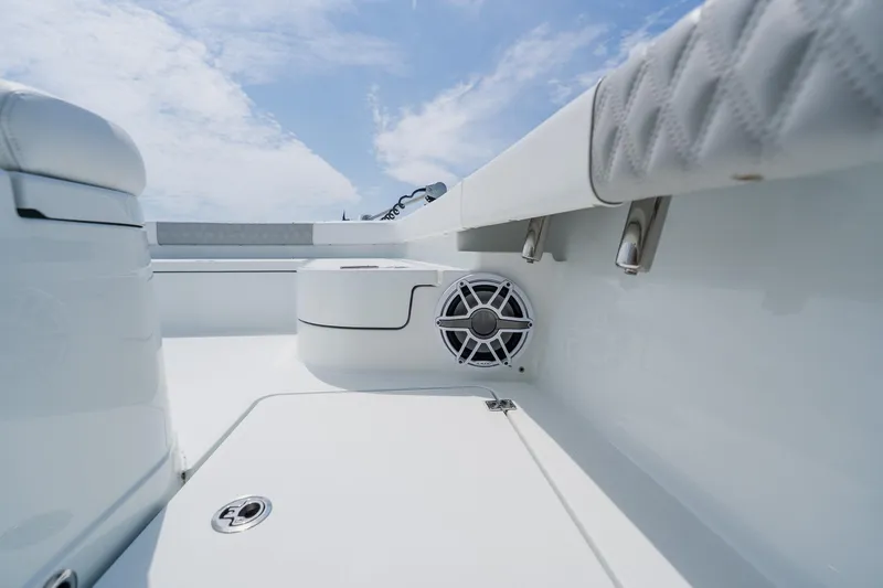 Slide: The Image of 2023 Freeman 28 boat interior with speaker, white seating, and blue sky background. - 19