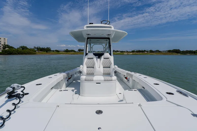 Slide: The Image of 2023 Freeman 28 boat on calm water, featuring sleek white design and spacious seating. - 20