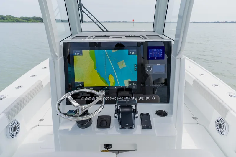 Slide: The Image of 2023 Freeman 28 boat dashboard with navigation display on calm water. - 31