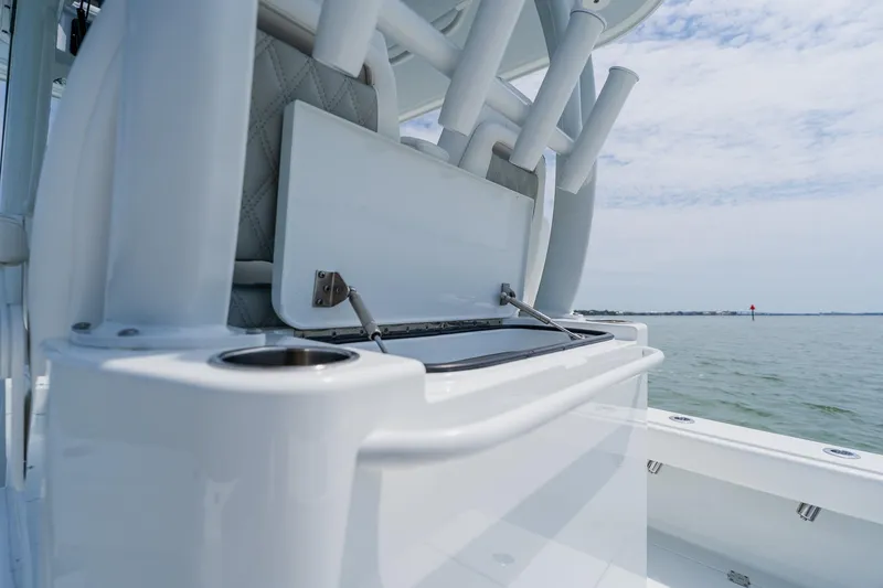 Slide: The Image of 2023 Freeman 28 boat interior with rod holders and storage, overlooking calm waters. - 37