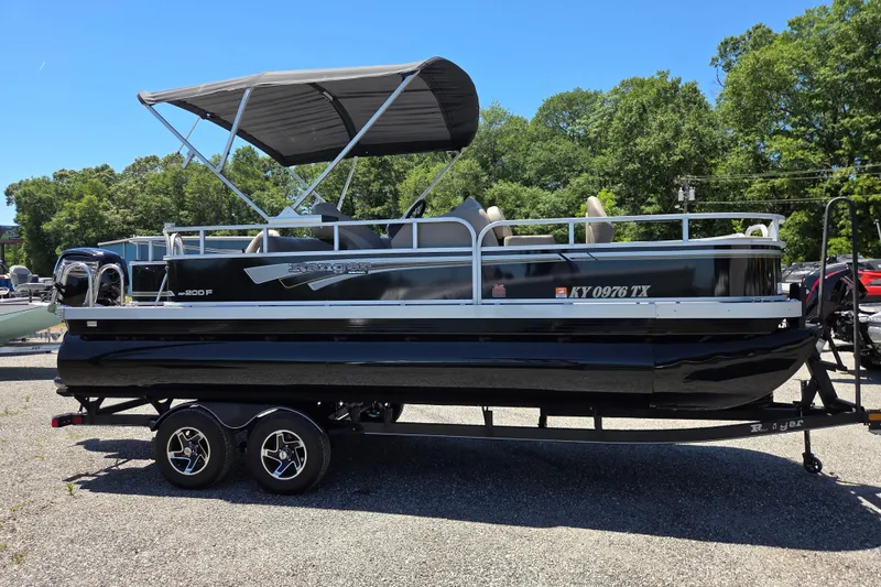 Slide: The Image of 2023 Ranger Reata 200F pontoon boat on trailer, parked outdoors. - 3