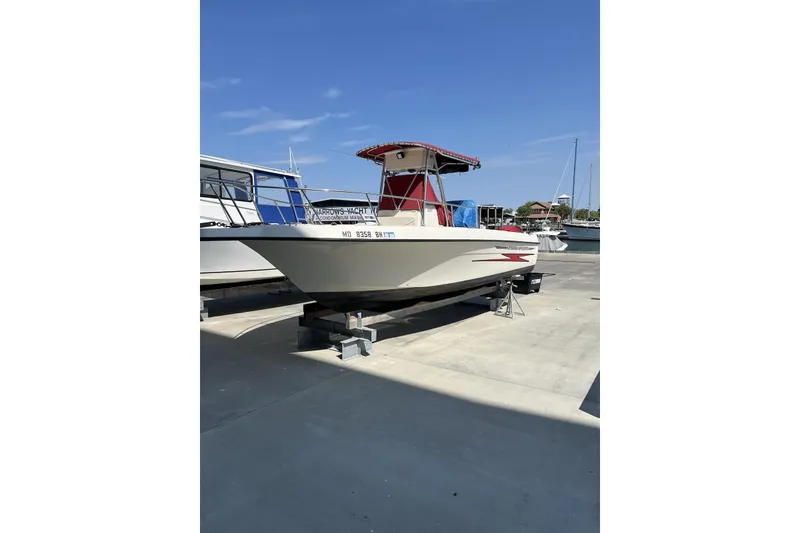 Slide: The Image of 1999 Hydra-Sports 230 CC boat on dry dock under clear blue sky. - 2