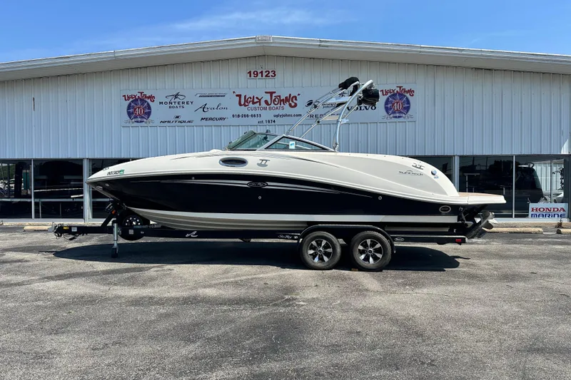 The Image of 2008 Sea Ray 260 Sundeck boat on trailer outside dealership building. - 1