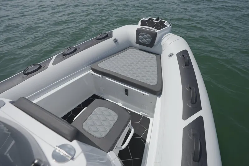 Slide: The Image of 2026 Highfield Sport 560 boat interior with cushioned seating on calm water. - 12