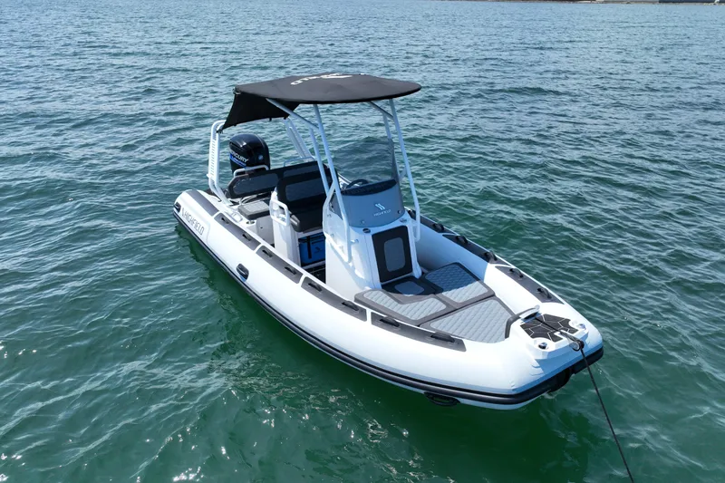 Slide: The Image of 2026 Highfield Sport 560 boat on calm water, featuring sleek design and modern canopy. - 2