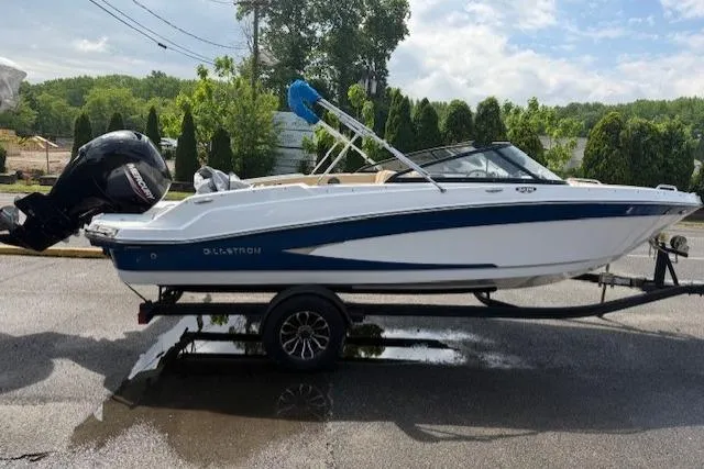 Slide: The Image of 2022 Glastron GX 210 Sport boat on trailer, featuring sleek design and powerful outboard motor. - 2