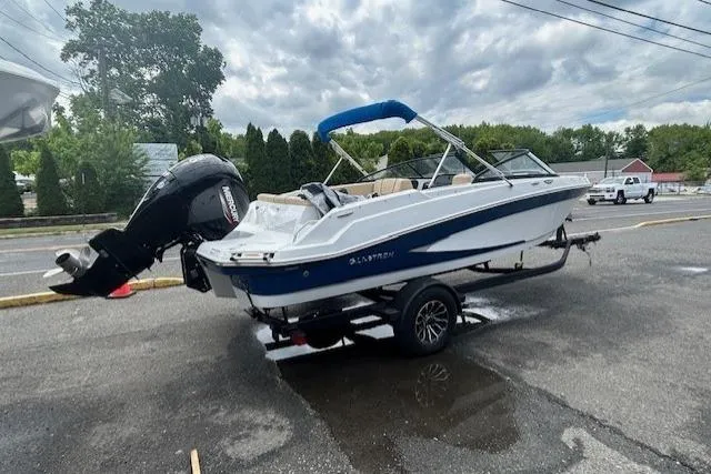 Slide: The Image of 2022 Glastron GX 210 Sport boat on trailer, parked outdoors under cloudy sky. - 3