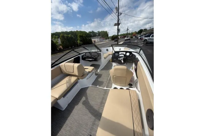 Slide: The Image of 2022 Glastron GX 210 Sport boat interior with beige seating and modern dashboard. - 4