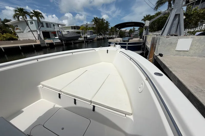 Slide: The Image of 2004 Triton 2895 CC boat docked in a sunny marina with palm trees. - 13
