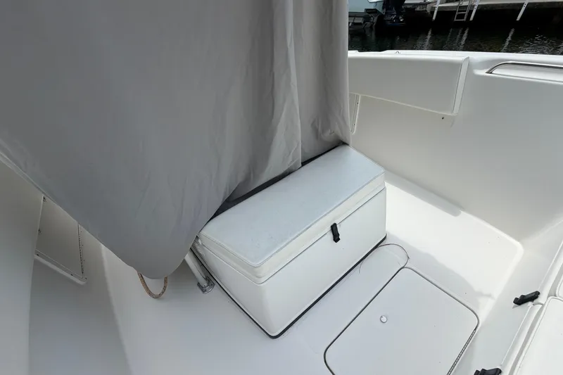 Slide: The Image of 2004 Triton 2895 CC boat interior with storage compartment and seating area. - 15