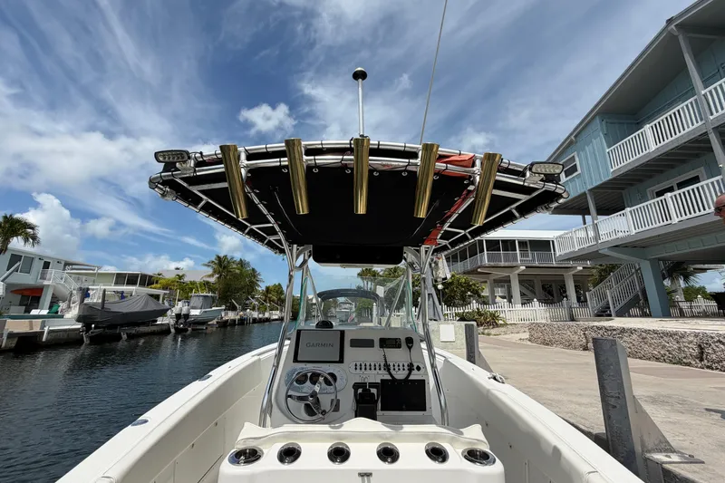 Slide: The Image of 2004 Triton 2895 CC boat docked by waterfront homes under a partly cloudy sky. - 19