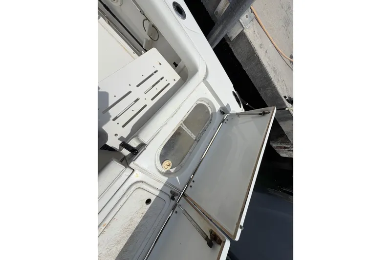 Slide: The Image of 2004 Triton 2895 CC boat interior with open storage compartments at dockside. - 20