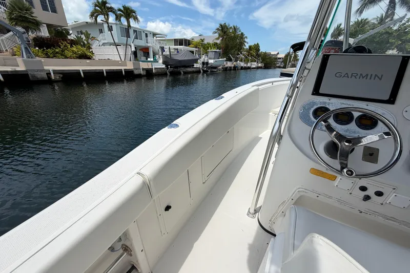 Slide: The Image of 2004 Triton 2895 CC boat with Garmin navigation, docked in a scenic canal. - 29