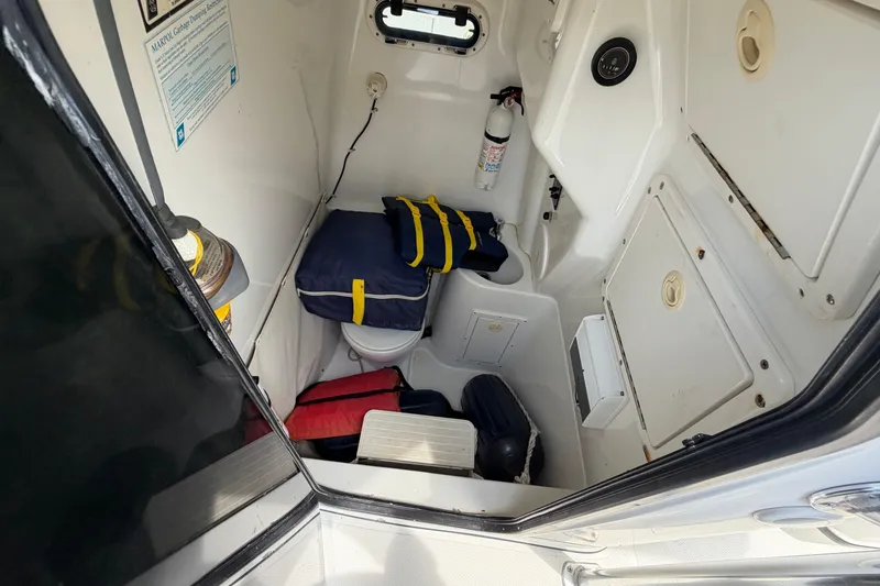 Slide: The Image of 2004 Triton 2895 CC boat cabin interior with safety gear and equipment. - 30
