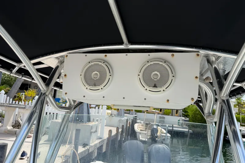 Slide: The Image of Triton 2895 CC 2004 boat speakers mounted under canopy, docked at marina. - 32